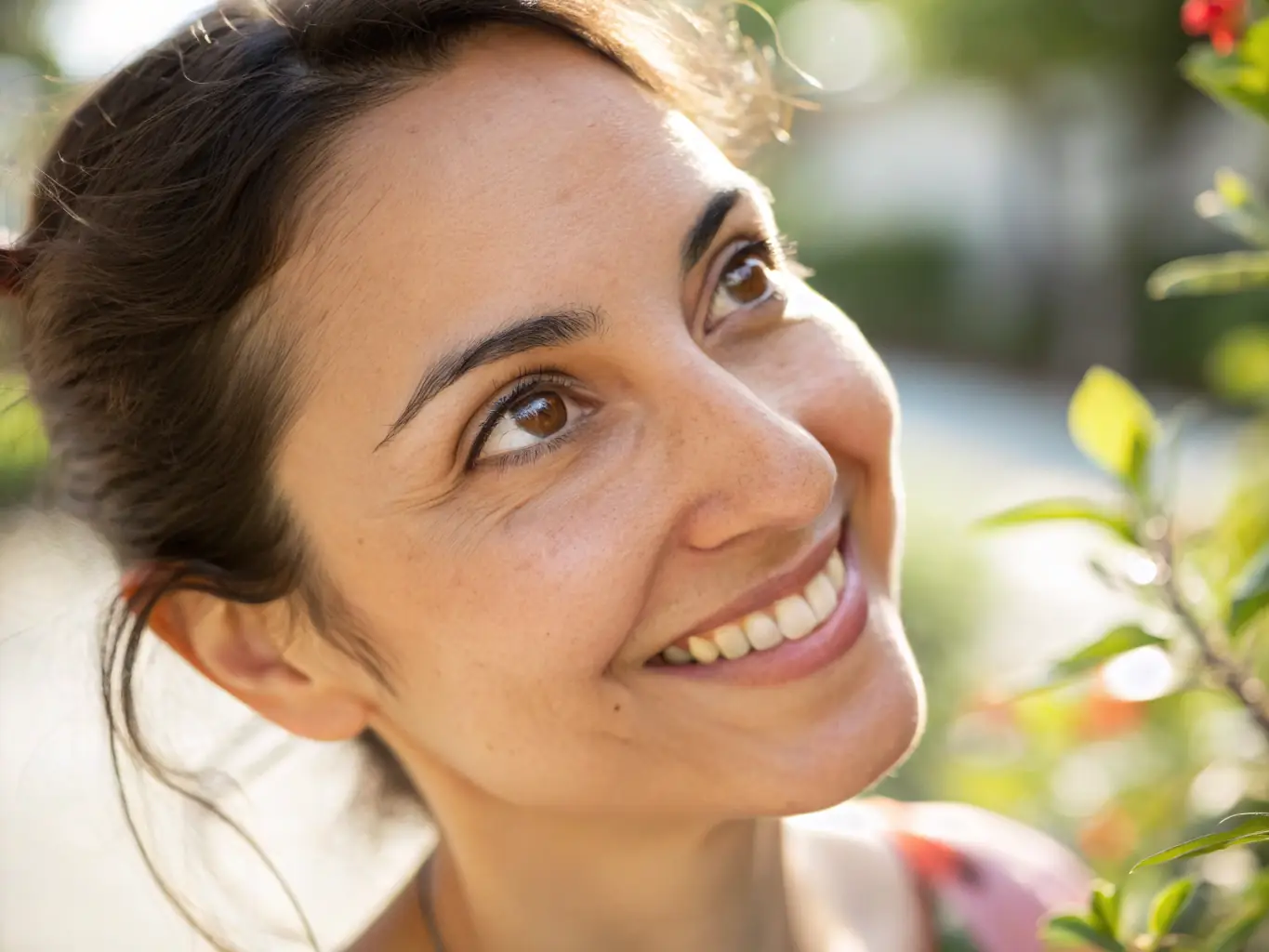 A close-up image of a mature woman smiling confidently, her skin looking smooth and radiant, set against a soft terracotta and dark green background that matches the Sacred Face Salon brand colors.